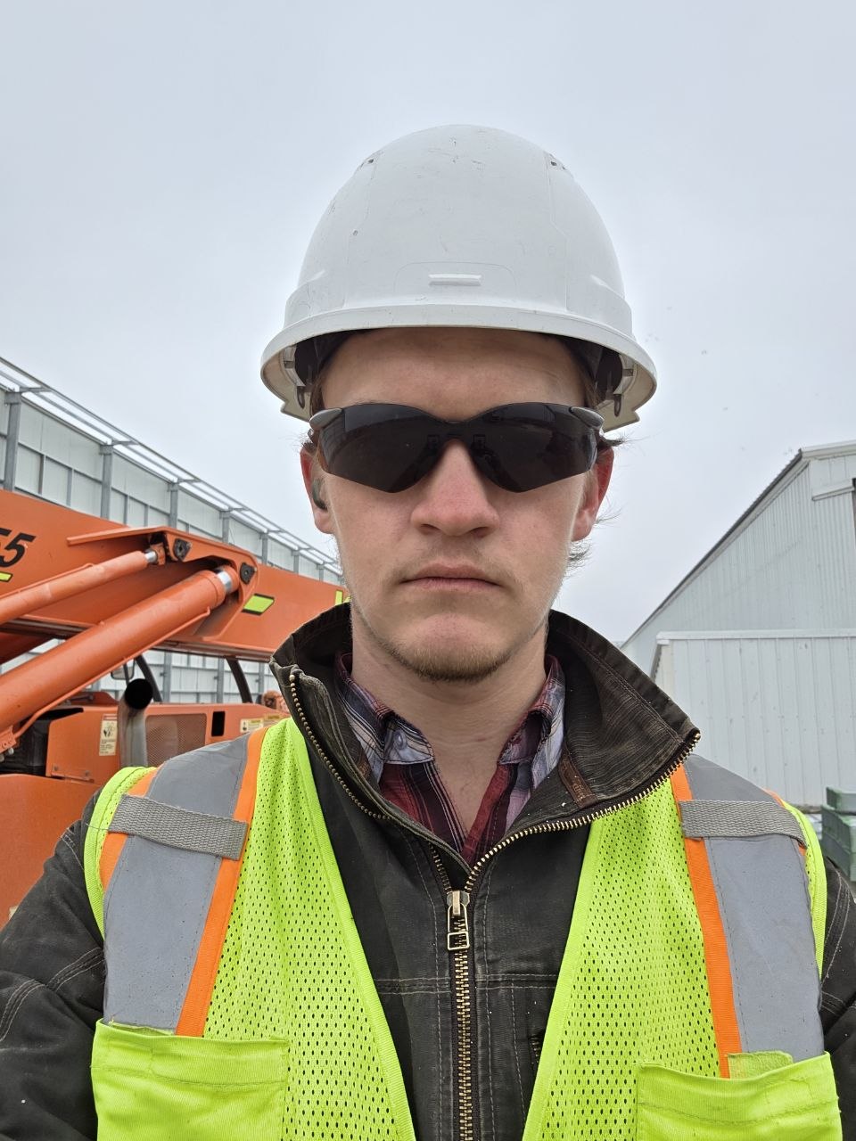Founder of WhiteFyr wearing a hard hat, safety glasses, and hi-vis vest on a jobsite